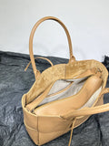 Tan leather tote bag with double handles, interior zipper compartment, and suede lining