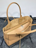 Tan leather woven tote bag with dual handles, interior zipper pouch, and soft suede lining