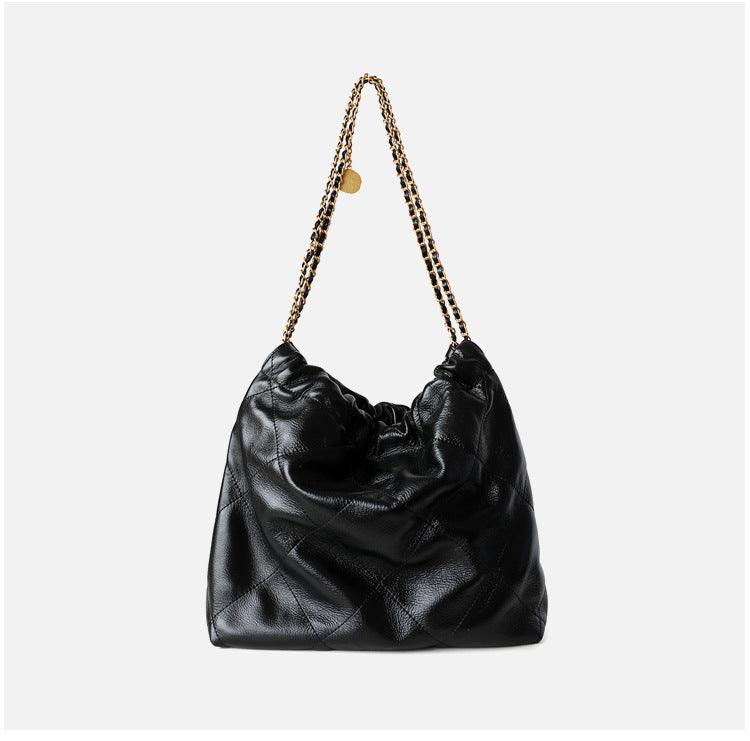 Large black quilted leather shoulder bag with gold-tone chain strap, minimalist tote style