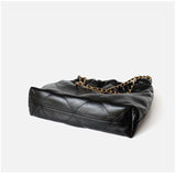 Black quilted leather shoulder bag with gold chain strap, minimalist design on white background.