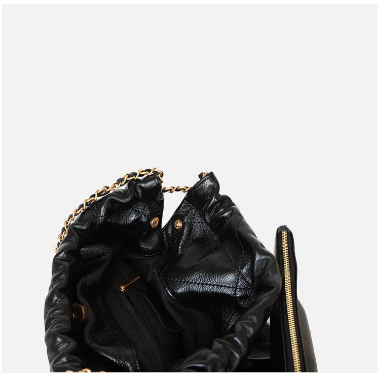 Interior of black calfskin leather shoulder bag with gold chain and zip pocket, minimalist tote