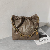 Brown quilted leather shoulder bag with gold-tone chain strap on a gray surface