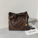 Brown quilted leather shoulder bag with gold chain strap on a table