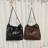 Black and brown quilted leather shoulder bags with gold-tone chain straps, hanging side by side