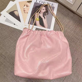 Pink quilted calfskin leather shoulder bag with gold-tone chain strap on a table