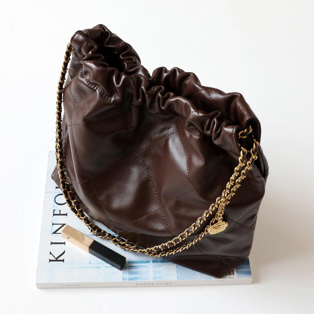 Brown quilted leather shoulder bag with gold chain strap on white surface