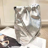 Silver quilted leather shoulder bag with gold-tone chain strap, minimalist design on magazine