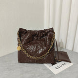 Large brown calfskin leather shoulder bag with gold chain strap on a grey surface