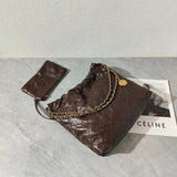 Brown quilted leather shoulder bag with gold chain strap and matching pouch on marble surface