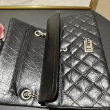 Woman in white outfit carrying a black quilted leather shoulder bag with silver chain strap