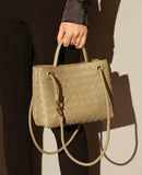 Beige woven leather shoulder bag with metal buckle, braided strap, and dual handles.