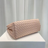 Light pink woven leather shoulder bag with intrecciato pattern on display pedestal