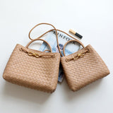 Tan woven leather shoulder bags with gold metal buckles on a white background