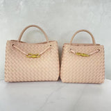Beige woven leather shoulder bags with top handles and gold metal buckles on white background
