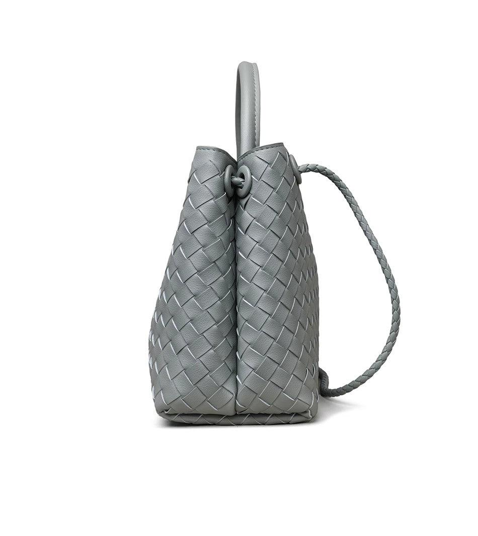 Side view of grey woven leather shoulder bag with braided handle and knot detail