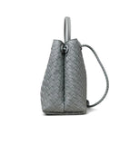 Side view of grey woven leather shoulder bag with braided handle and knot detail