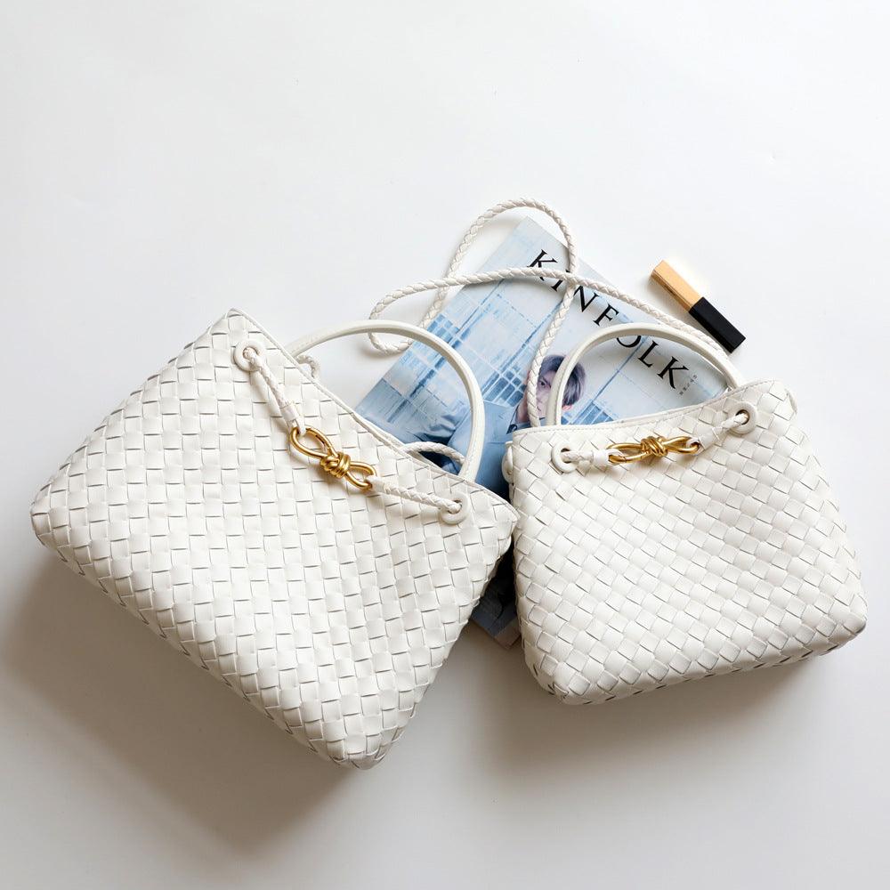 White woven leather shoulder bags with gold metal buckle on a white background
