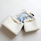 White woven leather shoulder bags with gold metal buckle on a white background