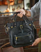 Handmade black cowhide leather shoulder bag with gold hardware and zippered front pocket
