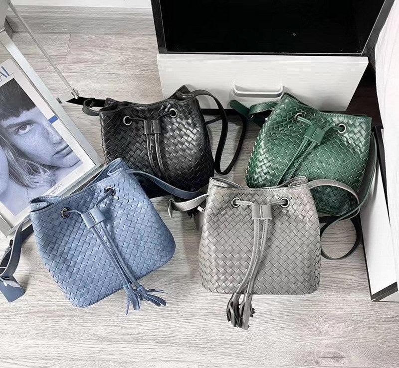 Handwoven lambskin leather bucket bags in black, green, blue, and grey with drawstring closure