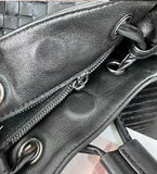 Close-up of black lambskin leather bucket bag with drawstring and zippered pocket detail