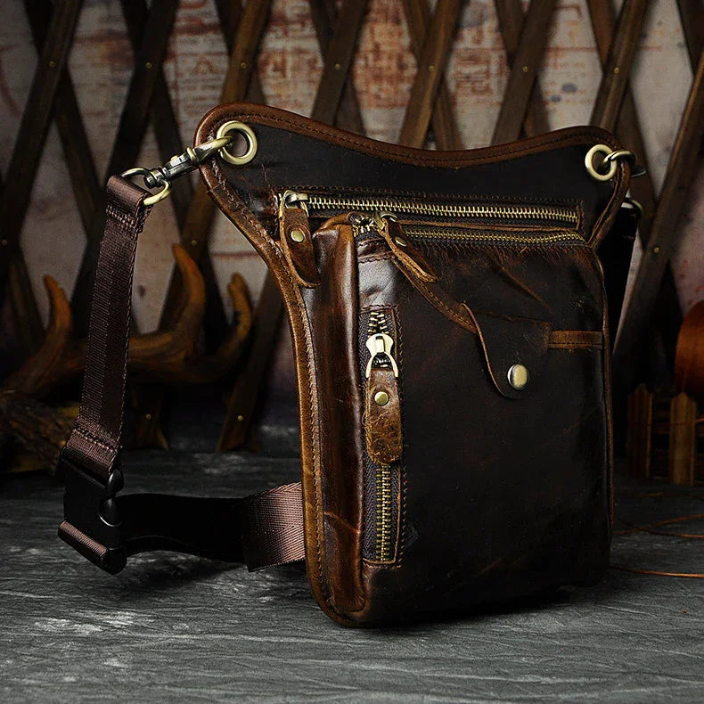 Full grain dark brown leather leg bag with zipper pockets and metal rivet details