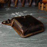 Full grain dark brown leather leg bag with zipper pockets and metal rivet details