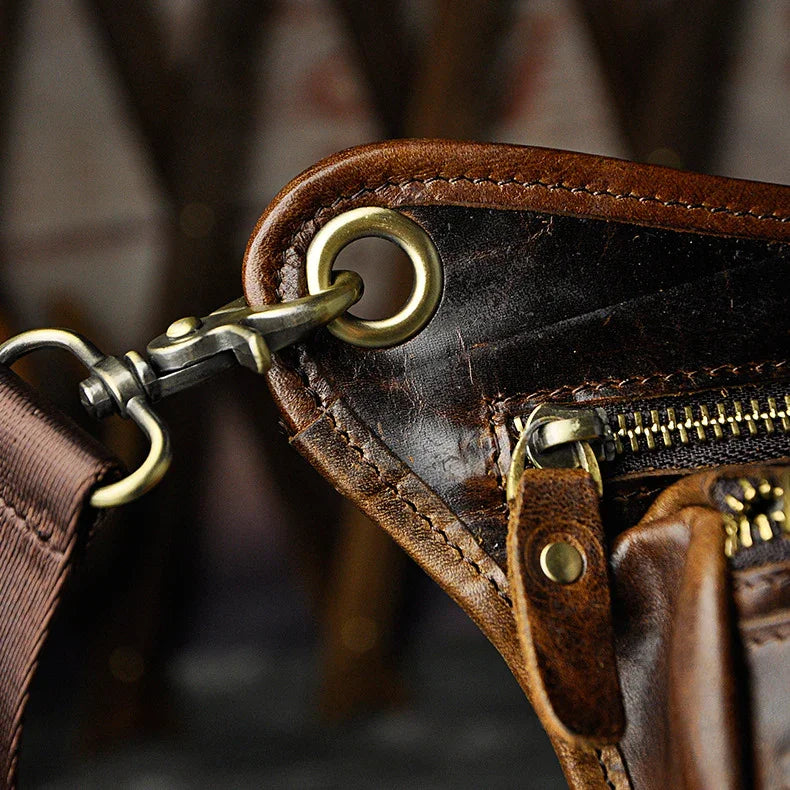 Full grain dark brown leather leg bag with zipper pockets and metal rivet details