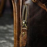 Full grain dark brown leather leg bag with zipper pockets and metal rivet details