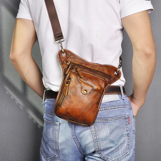 Full grain leather leg bag with multiple zippers, worn by person in jeans and white shirt