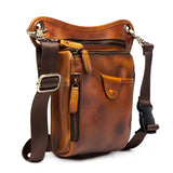 Full grain brown leather leg bag with multiple zippered pockets and adjustable straps