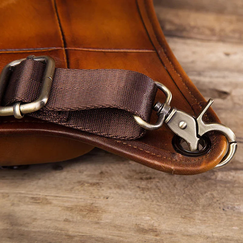 Close-up of a brown full grain leather leg bag with metal buckle and durable strap