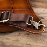 Close-up of a brown full grain leather leg bag with metal buckle and durable strap