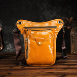 Full grain tan leather leg bag with multiple zip pockets and black adjustable strap on wood table