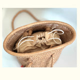 Hand-woven cowhide leather bucket bag with braided handle and drawstring closure