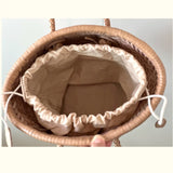 Top view of a hand-woven cowhide leather bucket bag with braided handles and drawstring closure