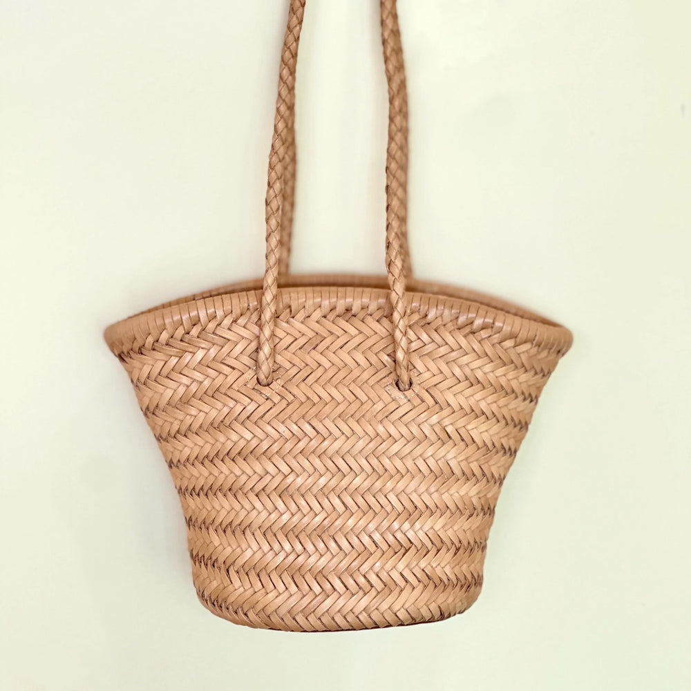 Hand-woven cowhide leather bucket bag with braided handles and herringbone pattern