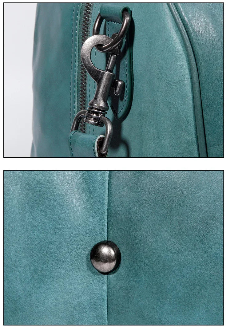 Close-up of teal full grain leather duffle bag with metal zipper, clasp, and button details