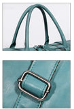 Close-up of teal full grain leather duffle bag handles and silver buckle detailing