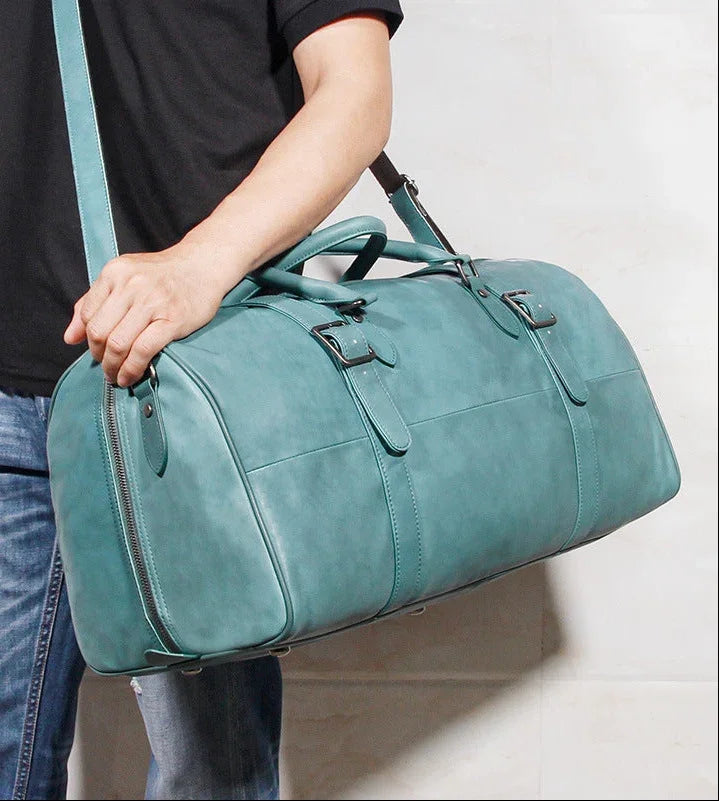 Handcrafted teal full grain leather duffle bag with shoulder strap and buckled handles
