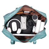 Open teal full-grain leather duffle bag with organized travel essentials, laptop, and accessories.