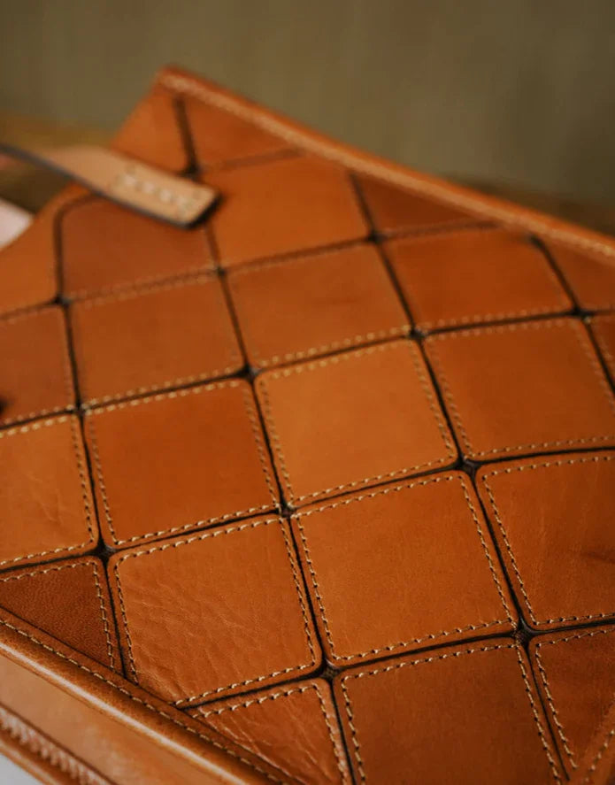 Handcrafted brown cowhide leather handbag with woven square pattern and visible stitching