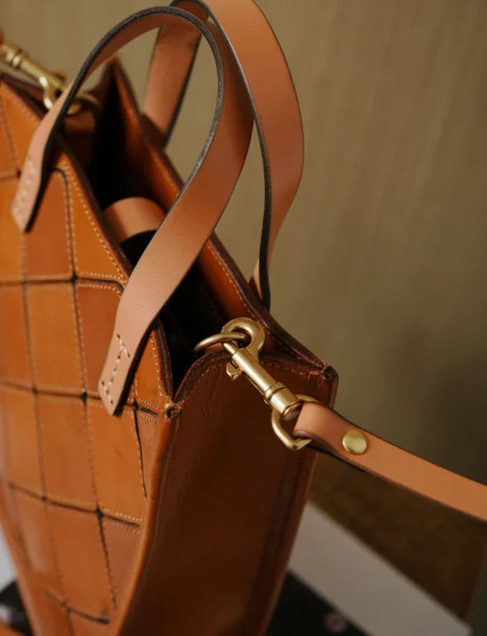 Handcrafted tan cowhide leather handbag with woven pattern and gold hardware