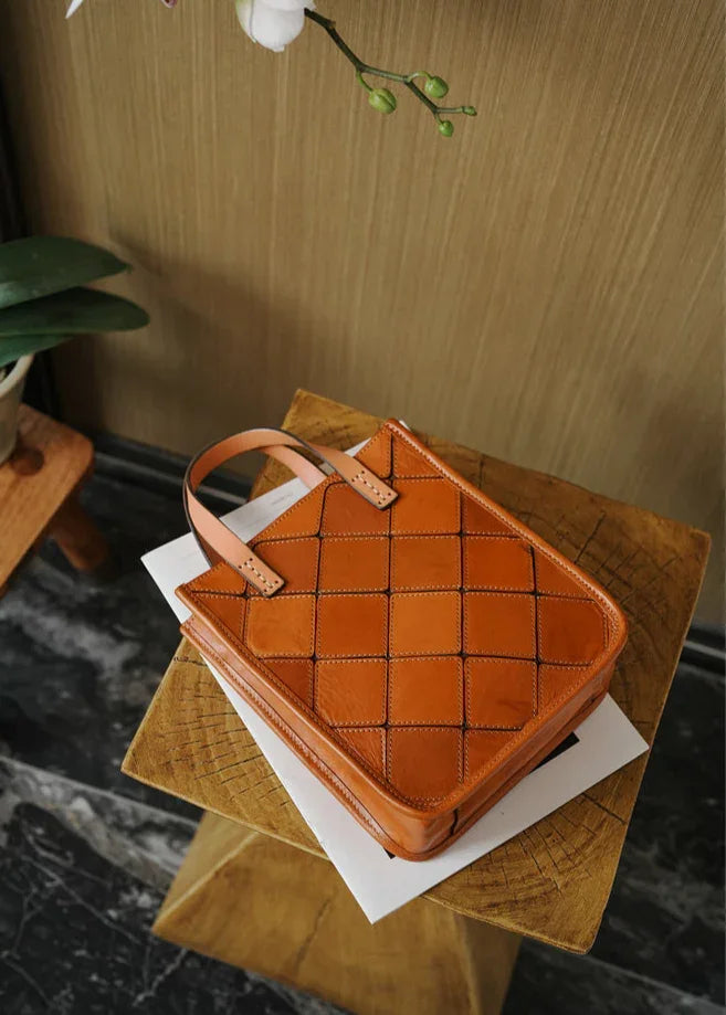 Handcrafted Italian cowhide leather handbag with quilted pattern on wooden table