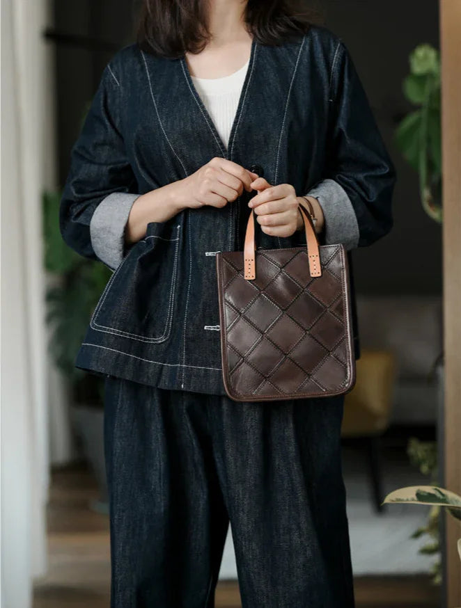 Woman holding a brown quilted cowhide leather handbag with tan handles, casual indoor setting