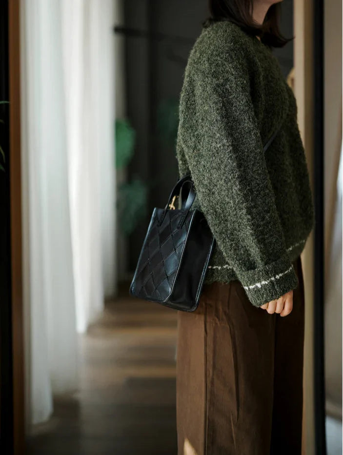 Woman wearing a green sweater with a black handcrafted cowhide leather shoulder bag