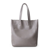 Large gray leather tote bag with dual handles, minimalist design, on white background