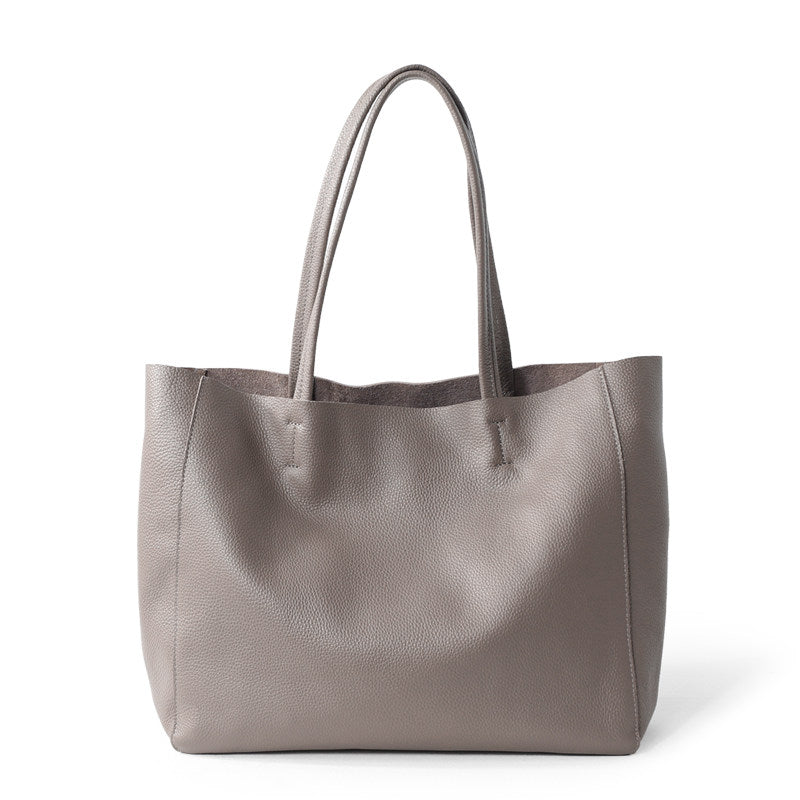 Large taupe handcrafted leather tote bag with double handles on white background