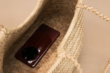 Interior of a handcrafted woven leather tote bag with a smartphone inside