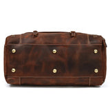 Bottom view of large dark brown full-grain leather duffle bag with metal feet and contrast stitching